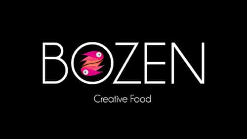 Logo avec le mot "BOZEN" en blanc, avec deux poissons roses stylisés formant le "O". Le texte "Creative Food" apparaît en dessous en lettres blanches plus petites sur fond noir.