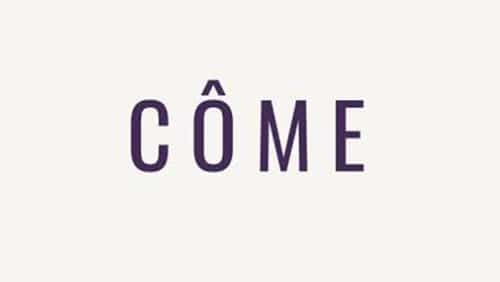 Le mot "CÔME" est écrit en lettres majuscules violettes foncées sur un fond clair uni.