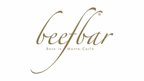 L'image montre le logo Beefbar en lettres d'or avec le slogan "Born in Monte-Carlo" sous le nom de la marque sur un fond blanc.