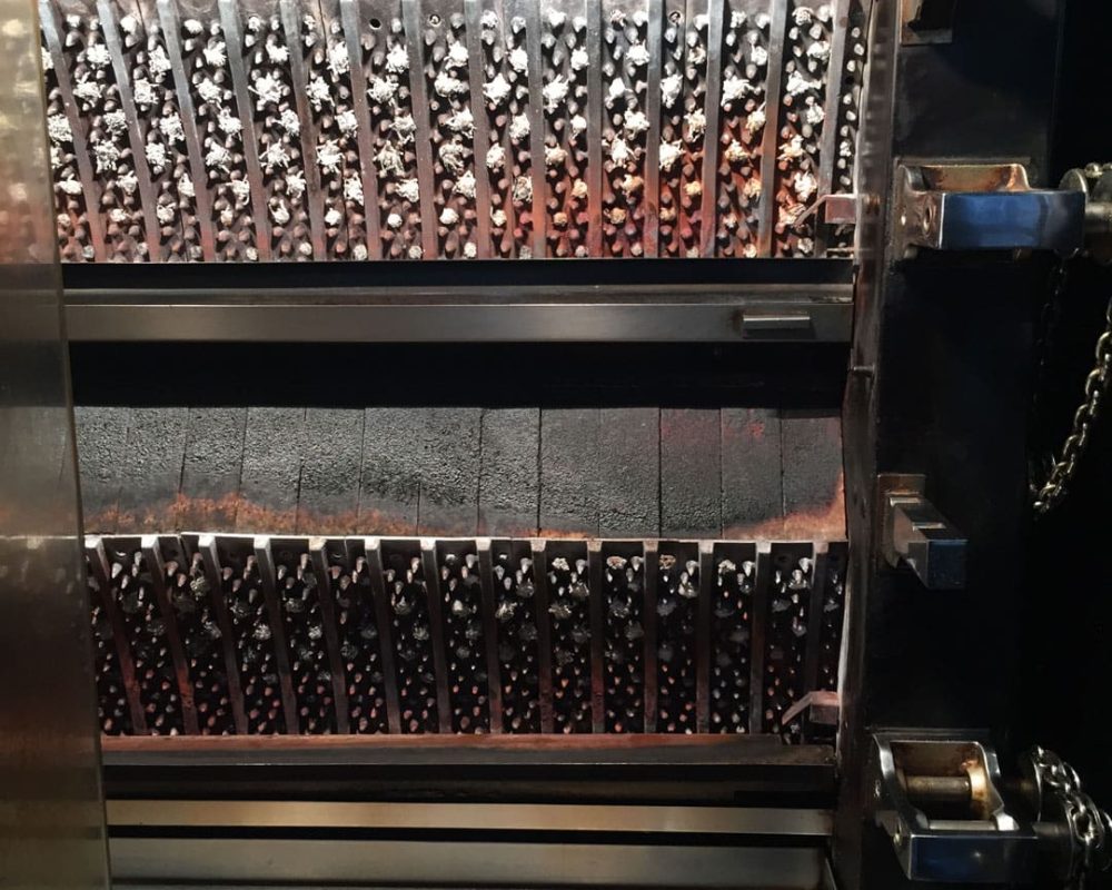 Une vue rapprochée de l'intérieur d'un grille-pain ou d'un four à griller commercial met en évidence les multiples éléments chauffants et les surfaces intérieures métalliques conçues pour une cuisson uniforme.